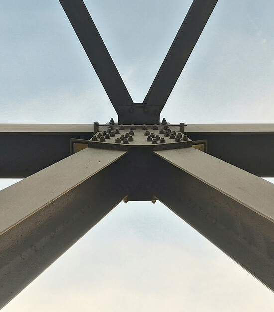 An image of several large iron beams converging outside. A visual metaphor for the topic of this article, Lawyers and project managers
