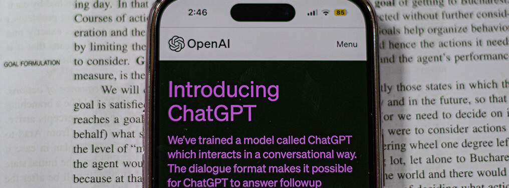 An image of a smartphone on a book, on the screen it mentions chat GPT. A visual metaphor for this article, navigating the world of AI